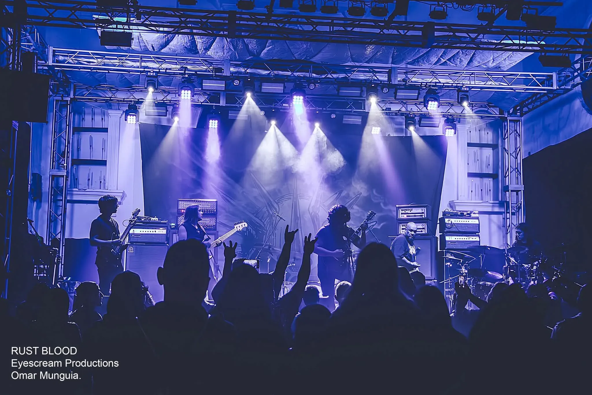 Rustblood live on a festival stage under blue lights